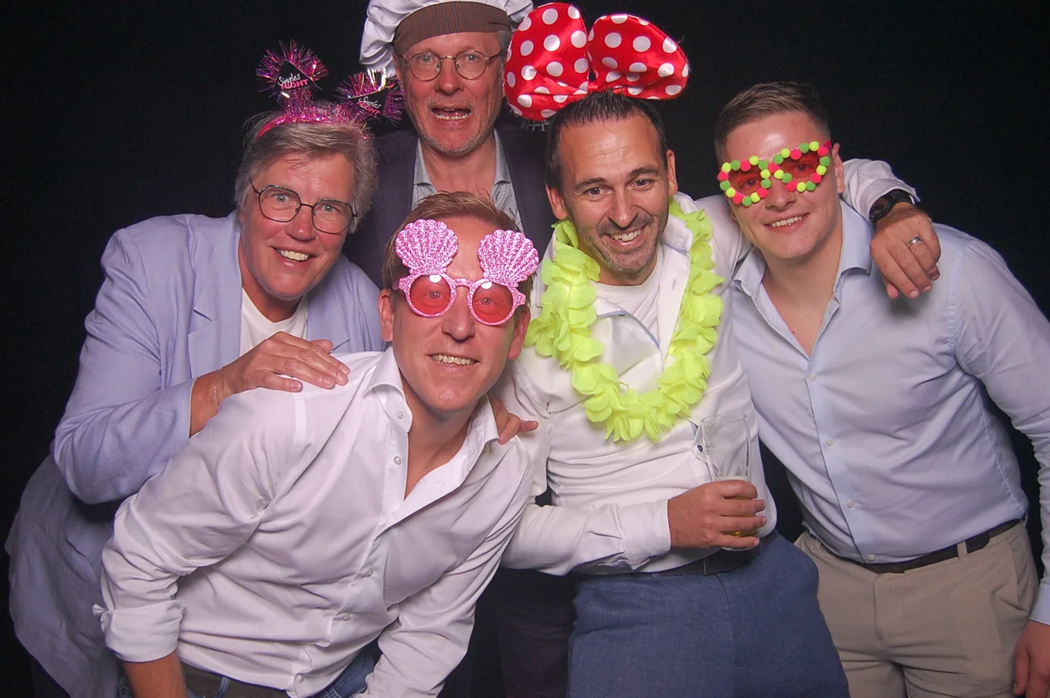 Groep mannen poseert met kleurrijke photobooth props